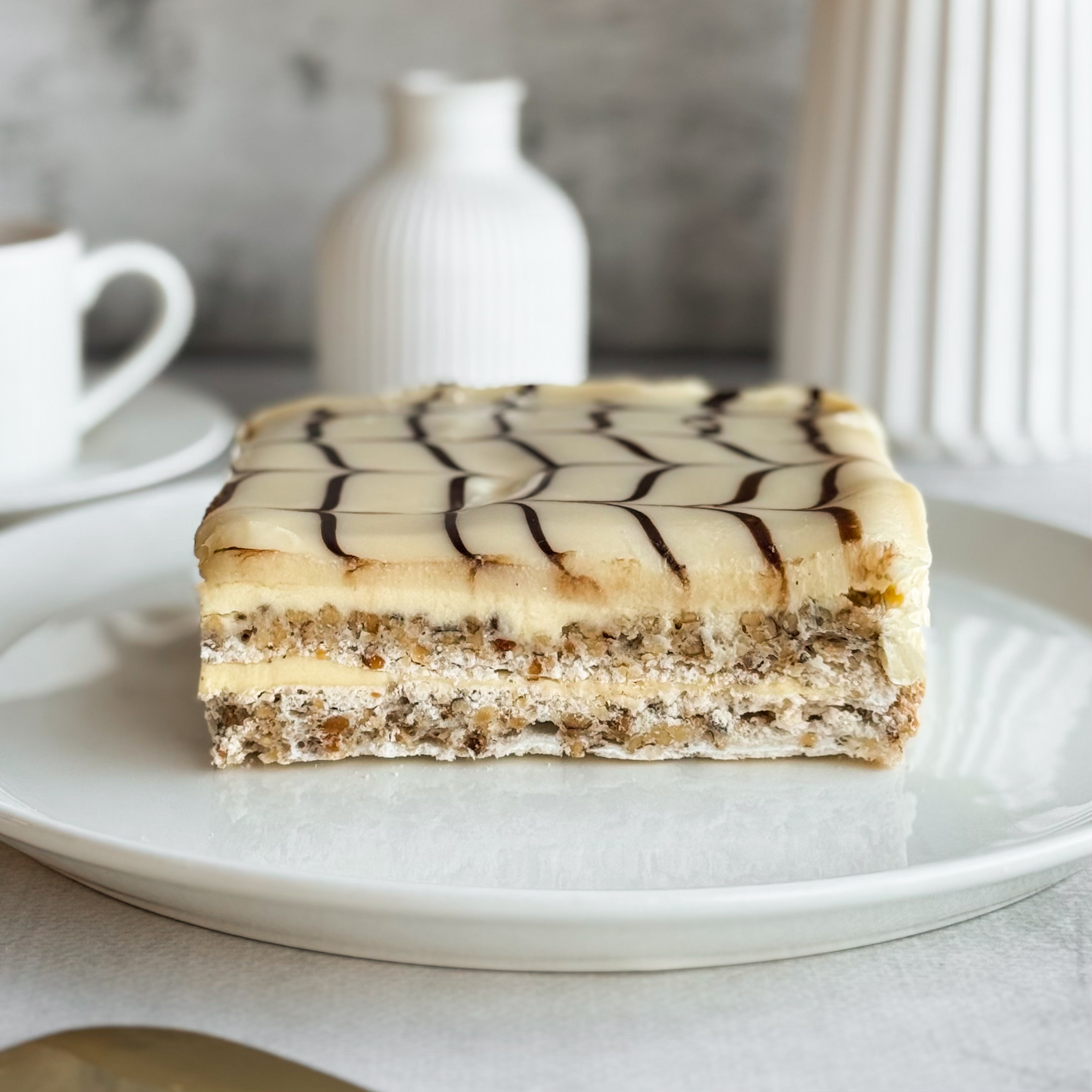  Бенто-торт Эстерхази в индивид.упаковке. Изысканный классический торт из воздушного ванильно-орехового бисквита, щедро дополненного нежным ванильно-сливочным кремом и посыпанного дробленным орехом. Сверху украшен сахарной помадкой и классическим мраморным рисунком. изображение 1