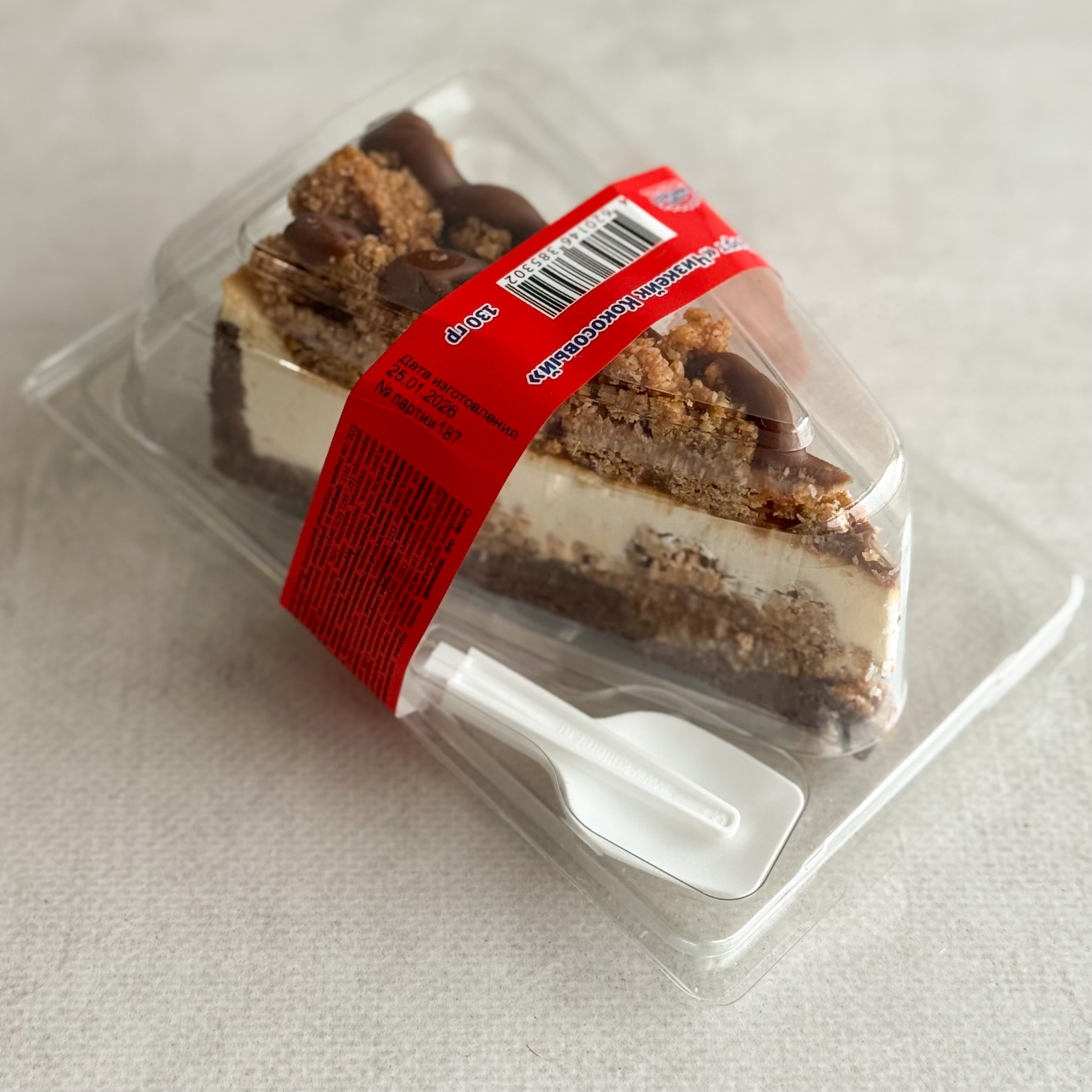 Нежный чизкейк из творожного сыра с начинкой из мягкого кокосового кранча с мякотью кокоса на песочно-шоколадной подложке. Сверху украшен кокосовым кранчем и залит карамелью. изображение 3