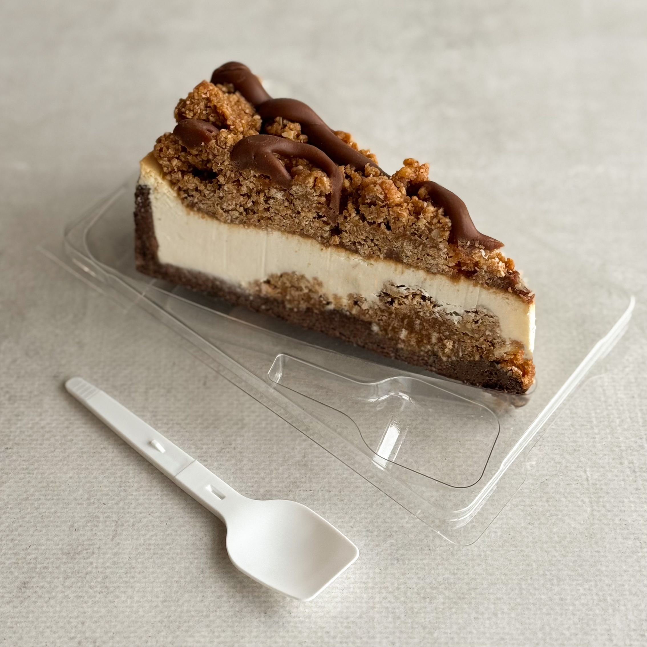 Нежный чизкейк из творожного сыра с начинкой из мягкого кокосового кранча с мякотью кокоса на песочно-шоколадной подложке. Сверху украшен кокосовым кранчем и залит карамелью. изображение 4