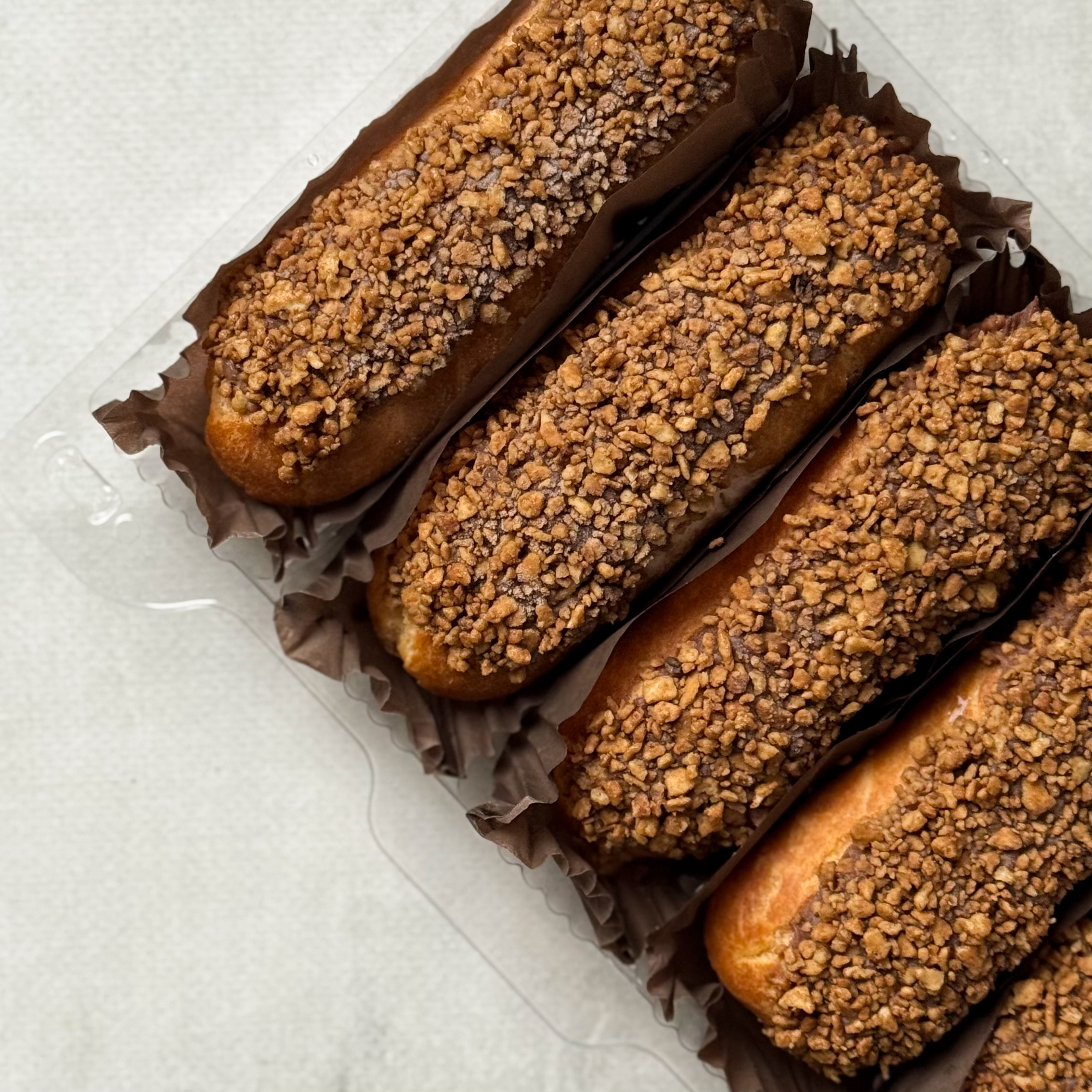 Ванильный эклер с начинкой из сливочного крема, покрытый шоколадной помадкой с посыпкой изображение 2