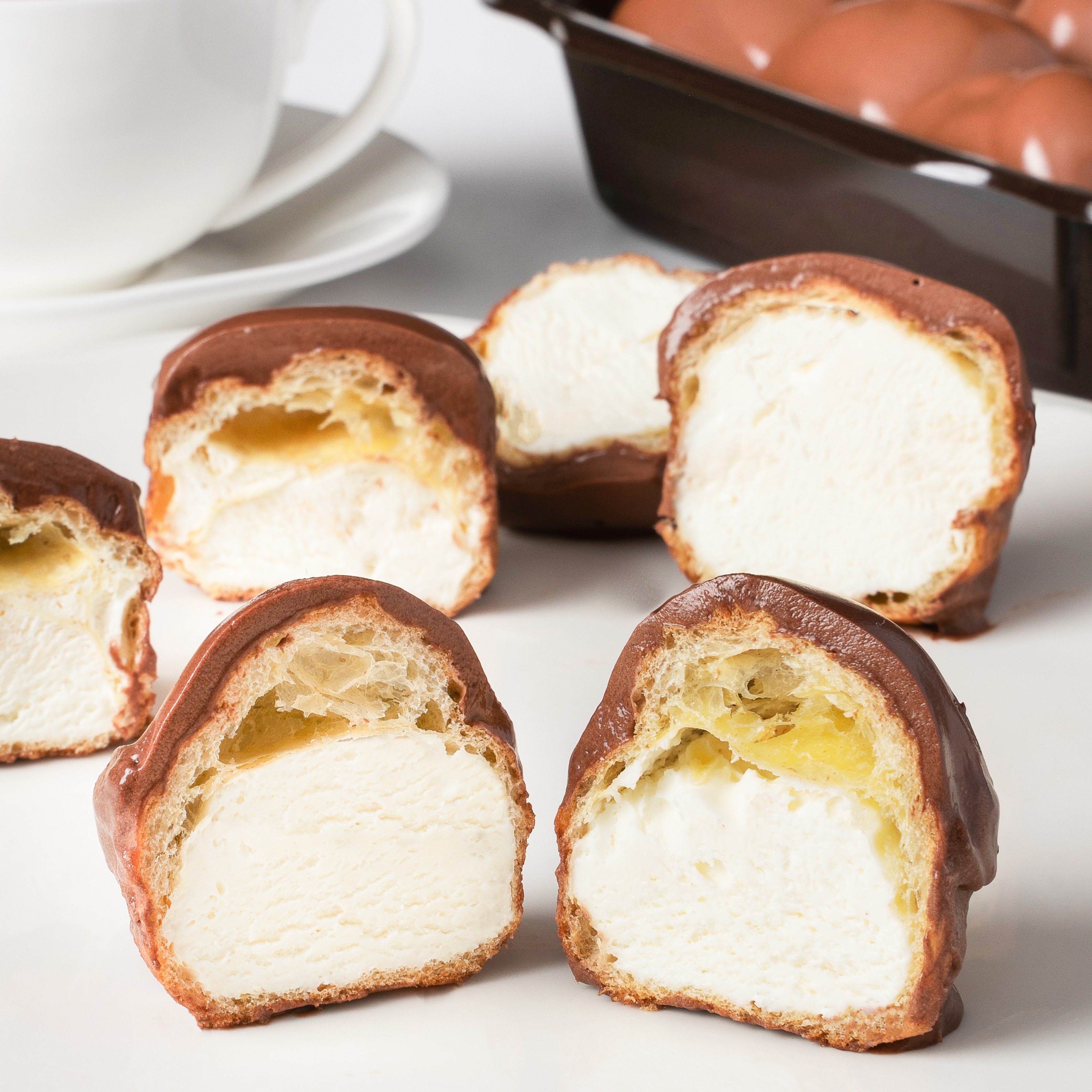 Большие профитроли из заварного теста с начинкой из свежих взбитых сливок, покрытые нежнейшим шоколадно-сливочным соусом. изображение 4