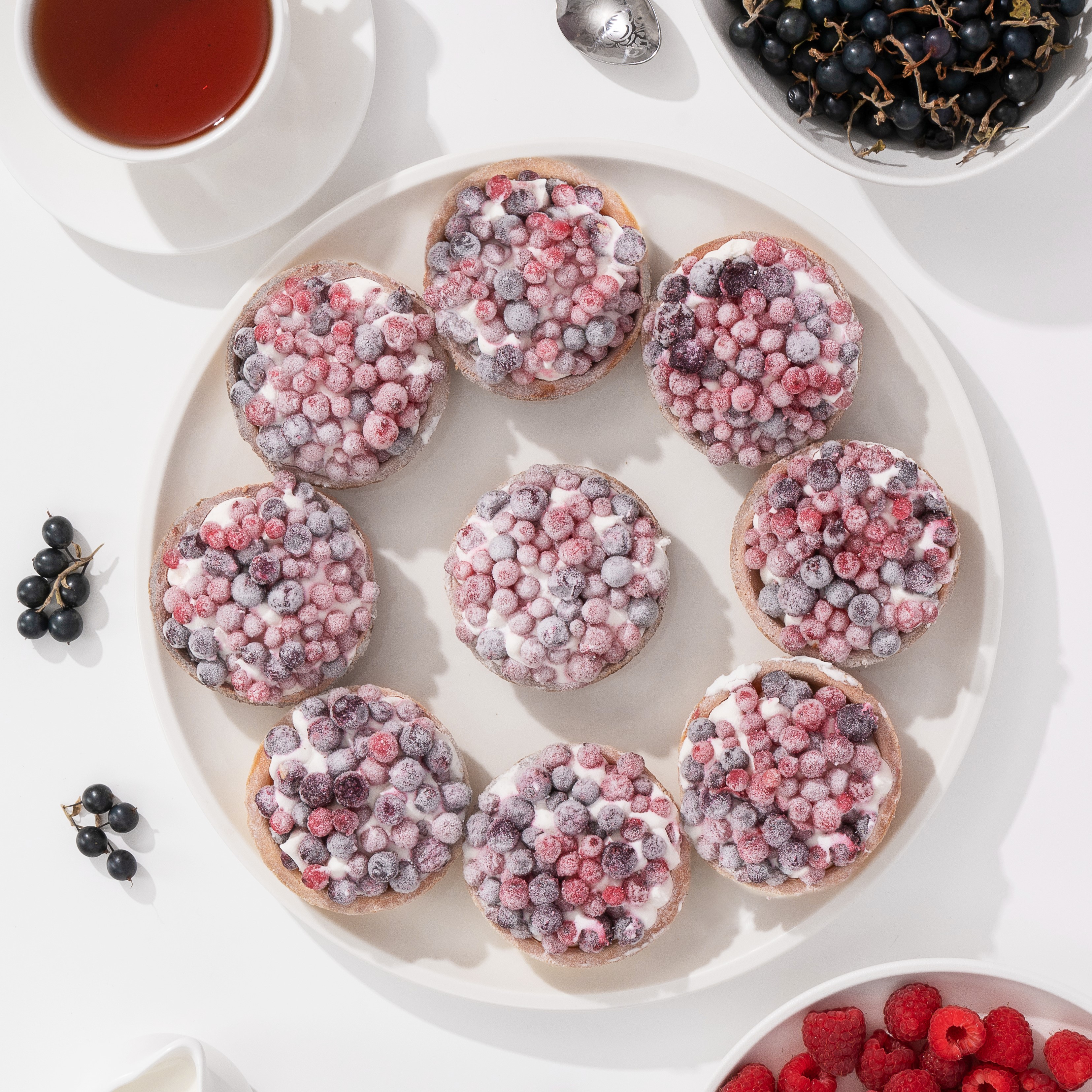 Ягодная тарталетка с начинкой из пюре чёрной смородины, взбитыми сливками и ягодами чёрной смородины в корзиночке из песочного теста. изображение 3