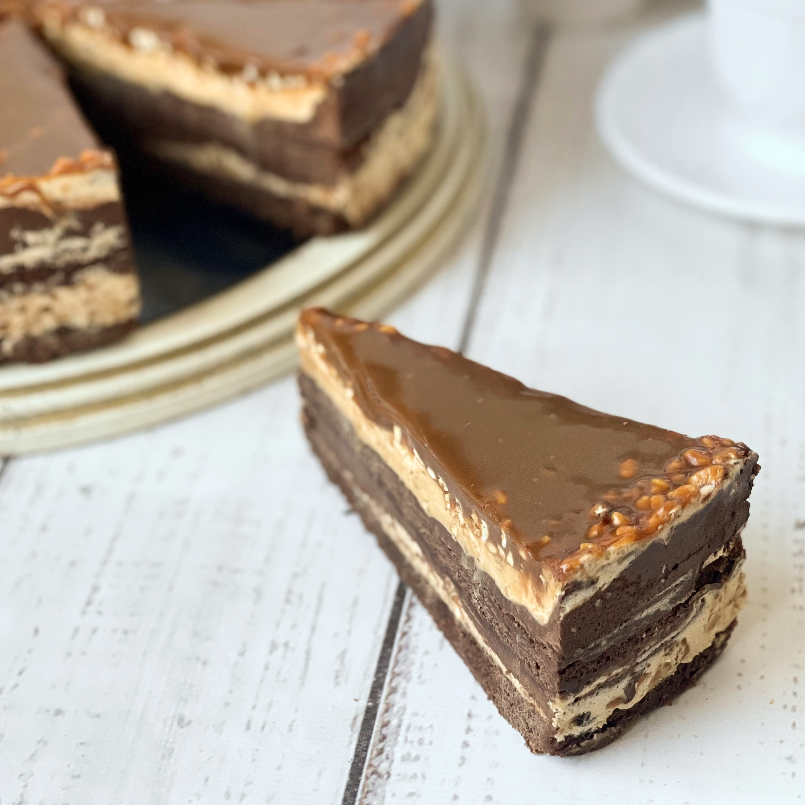 Два слоя насыщенного шоколадом брауни с прослойкой из ореховой нуги.  Торт покрыт плотным слоем мягкой карамели. изображение 4