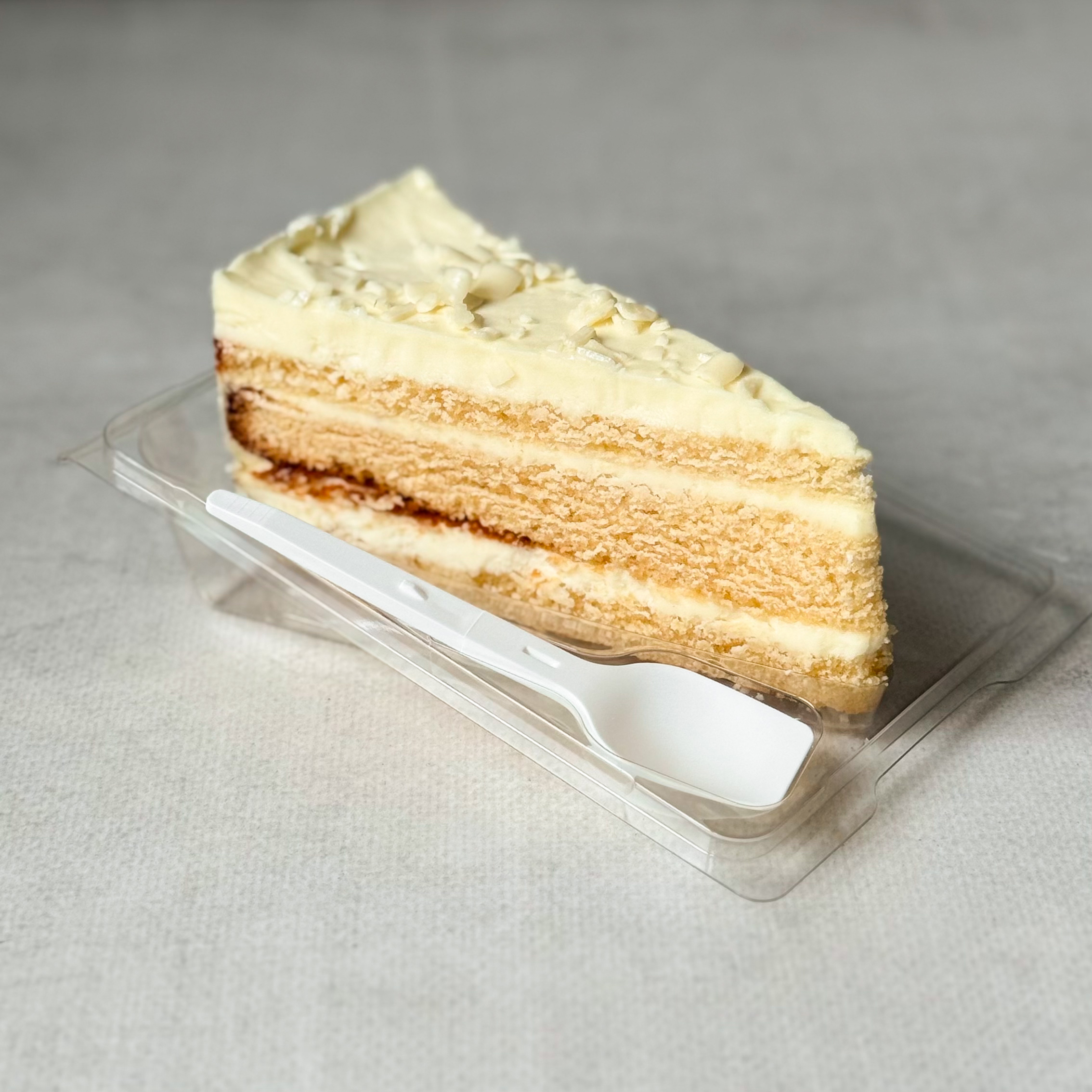 Изысканный торт из слоев нежного бисквита и творожного крема. Сверху торт украшен посыпкой из белого шоколада. изображение 4