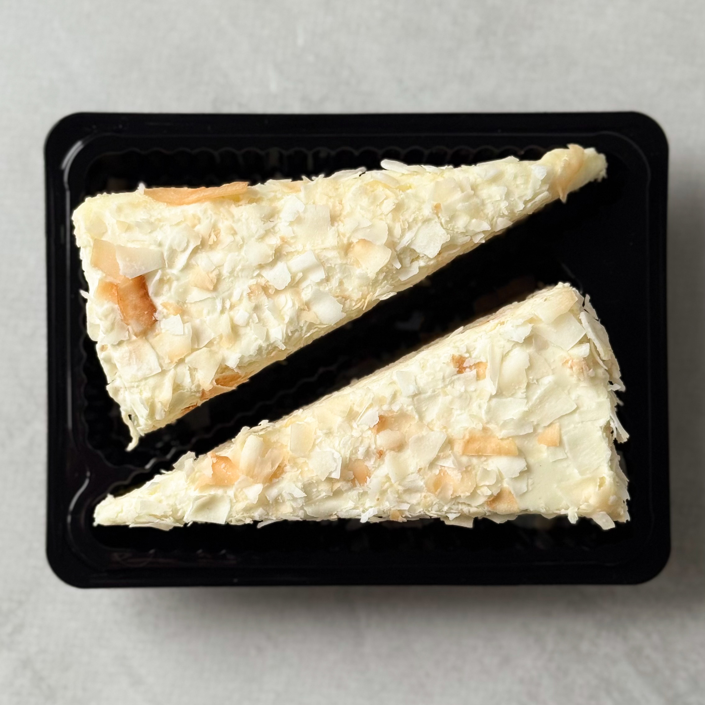 Изысканный торт из слоев кокосового бисквита, крема на основе белого шоколада, взбитых сливок и сочного слоя ананасового конфитюра с кусочками ананаса. Сверху торт украшен обжаренным кокосовым кранчем. изображение 5