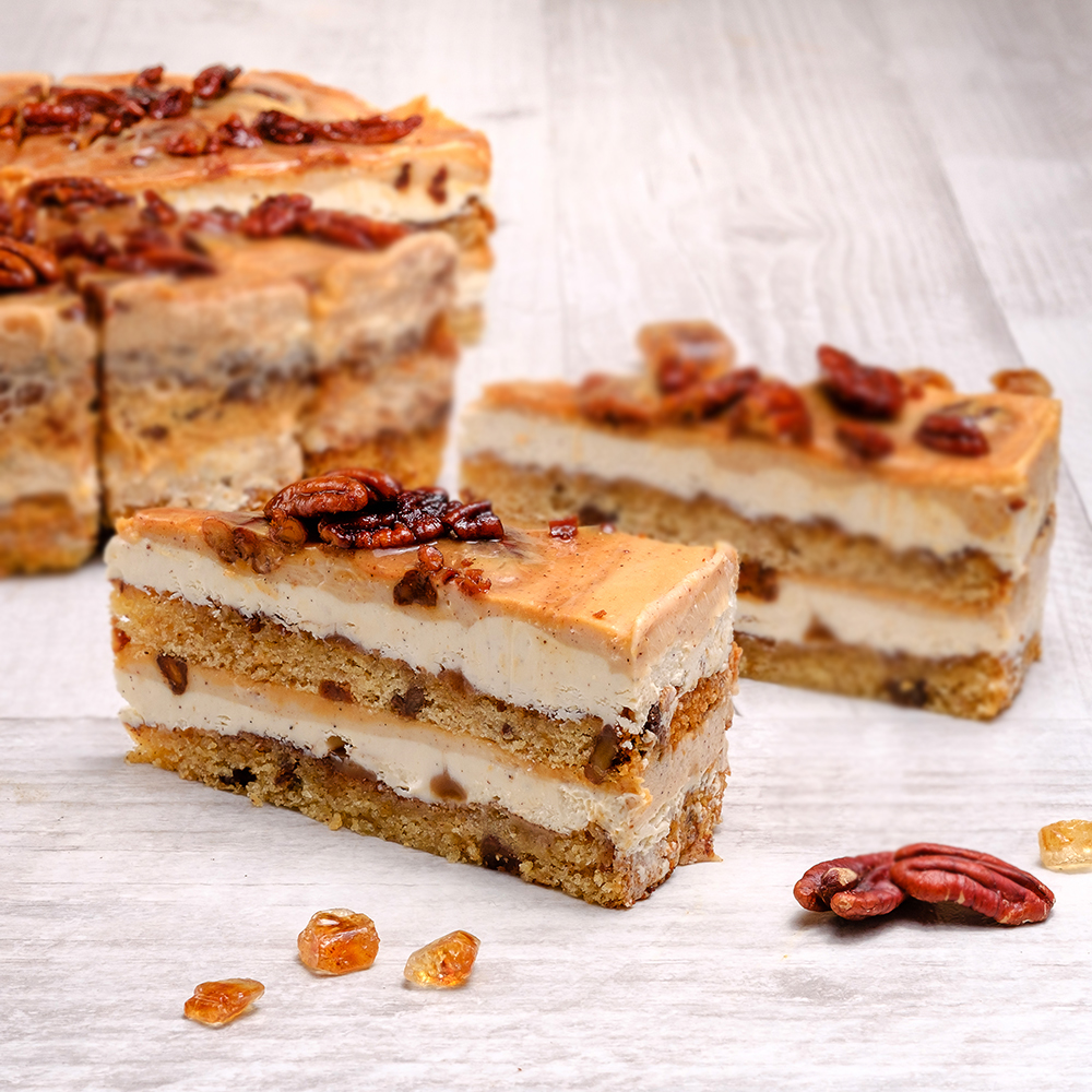 Между воздушных бисквитов с грецкими орехами две прослойки из нежного крема с корицей и карамелью. Сверху полит толстым слоем карамели с корицей и украшен горстью грецких орехов.  изображение 1