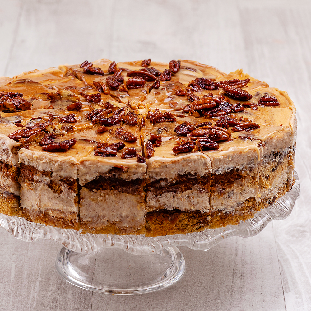 Между воздушных бисквитов с грецкими орехами две прослойки из нежного крема с корицей и карамелью. Сверху полит толстым слоем карамели с корицей и украшен горстью грецких орехов.  изображение 2