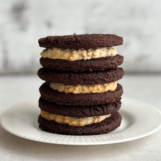 Вупи пай «Брауни с арахисовой пастой» - это два мягких шоколадных печенья брауни с насыщенным какао и нежной кремовой начинкой из арахисовой пасты. Идеальный баланс сладости и легкой ореховой нотки.